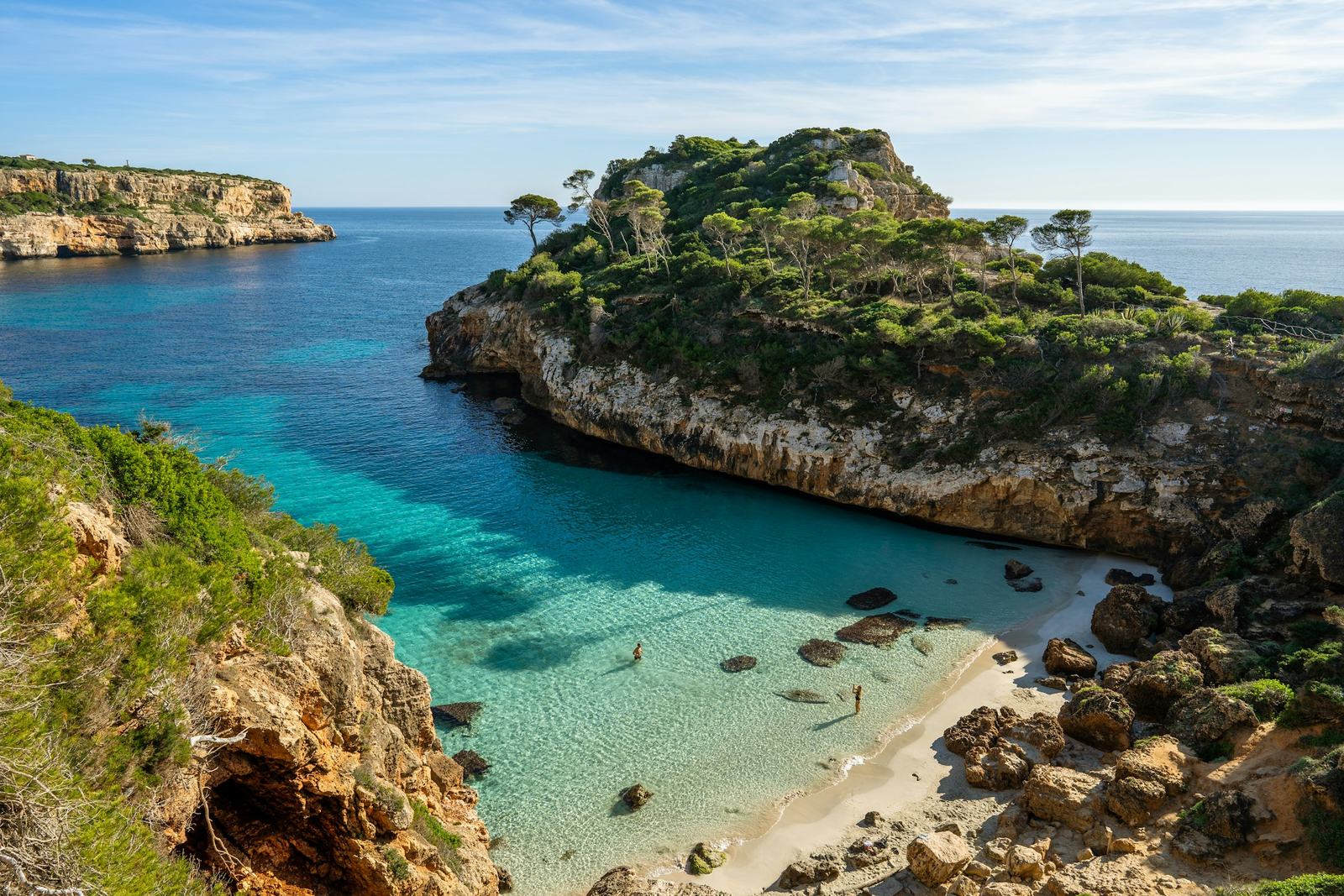 A turquoise cove in Mallorca with pine-covered cliffs
